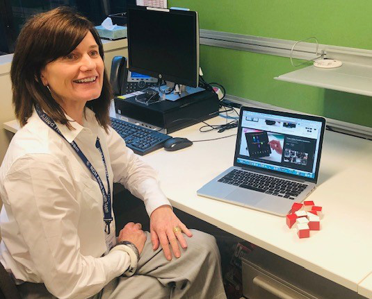 Associate Professor Maria McCarthy sits at her desk, looking up.